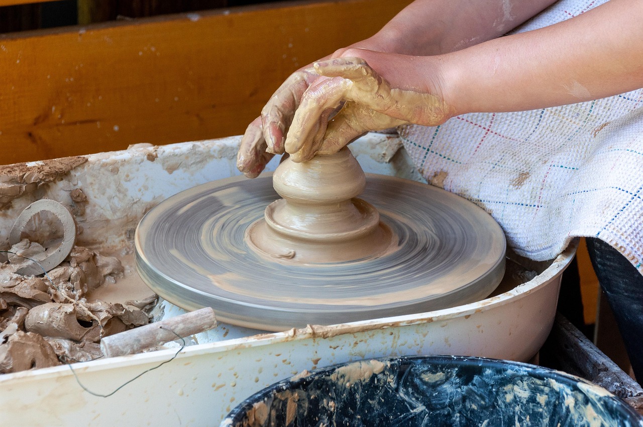 Vasaio al tornio a Grottaglie, mentre crea un vaso di ceramica artigianale.