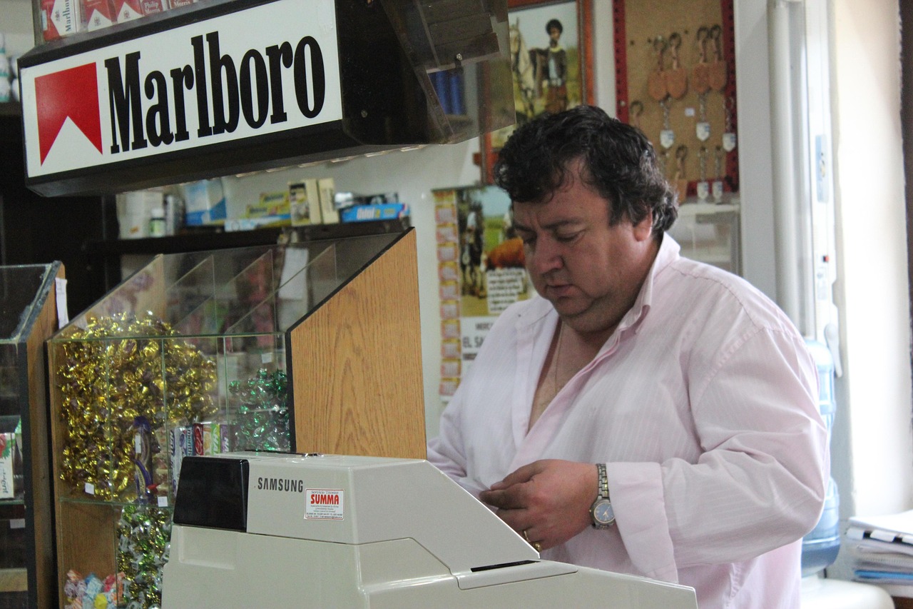 Tabaccaio mentre mostra diversi biglietti Gratta e Vinci a un cliente curioso.