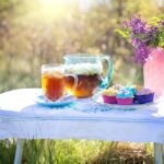 Tè freddo versato su piante in vaso, illustra l'uso come fertilizzante naturale.